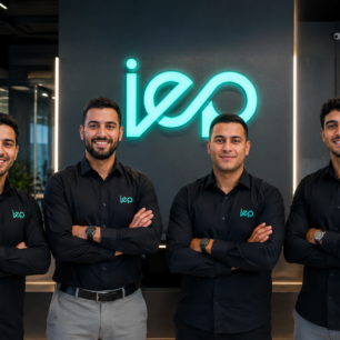 فريق عمل IEP ITEGYPRO المصري يقف معًا داخل مقر الشركة أمام شعار IEP